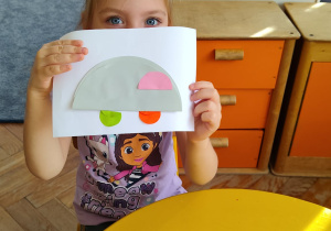 Dziewczynka prezentuje swoją pracę