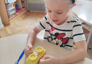 Dziewczynka czyści model zębów.