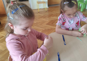 Dziewczynka czyści model zębów.