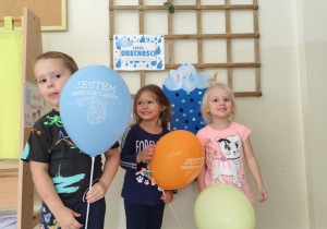 Dzieci trzymają balony.