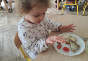 Dziewczynka samodzielnie komponuje kanapkę.