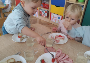 Chłopiec nakłada warzywa na swój talerzyk.