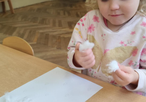 Dziewczynka wykonuje pracę plastyczną.