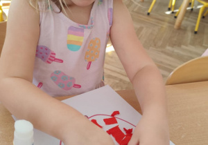 Dziewczynka wykonuje pracę plastyczną.