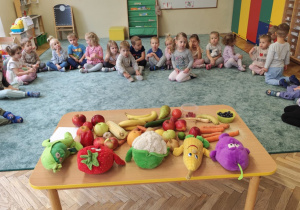 Dzieci oglądają owoce i warzywa.