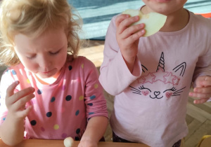 Dziewczynki jedzą owoce.