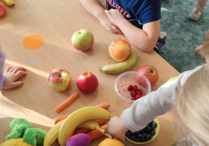 Dzieci poznają owoce za pomocą dotyku.