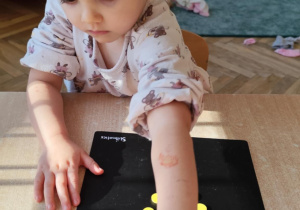 Dziewczynka układa kolorowe kółeczka.