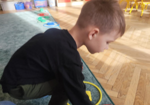 Chłopiec przyporządkował woreczek do zbioru czerwonego.