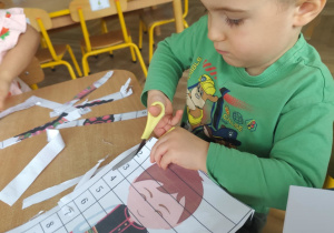 Chłopiec wycina puzzle.