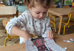 Dziewczynka wycina puzzle.