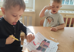 Chłopiec wycina puzzle.