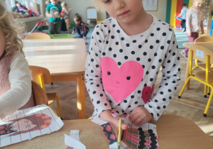 Dziewczynka wycina puzzle.