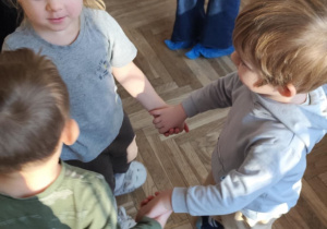 Dzieci tańczą w kółeczku.