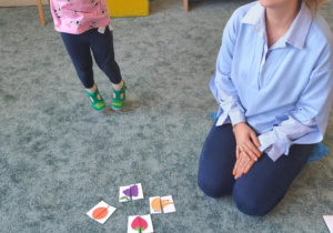 Dziewczynka z mamą ułożyła połówki owoców.