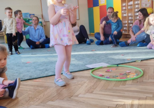 Dziewczynka klasyfikuje owoce i warzywa.