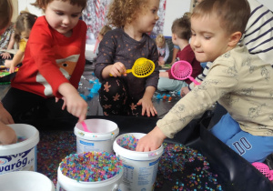 Dzieci bawią się żelowymi kuleczkami.