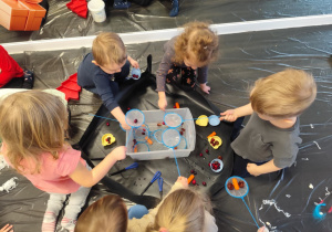 Dzieci wyławiają z wody różne przedmioty.