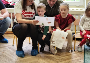 Dzieci z rodzicami śpiewają kolędy.