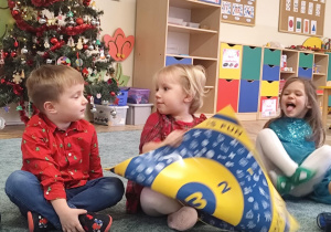 Dzieci oglądają planszę do rzutek.