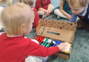 Dzieci rozpakowują prezent.