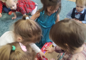 Dzieci rozpakowują prezent.