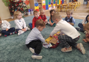 Dzieci rozpakowują prezent.