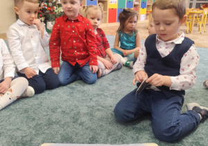 Dzieci oglądają planszę do rzutek.