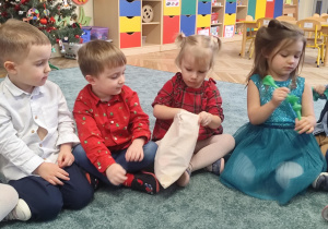 Dzieci wyciągają rzutki z woreczka.