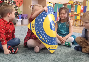 Dzieci oglądają planszę do rzutek.