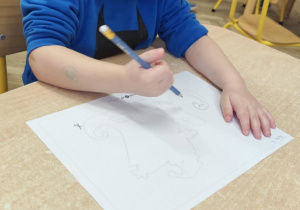 Chłopiec wykonuje pracę indywidualną.