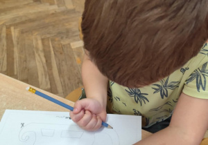 Chłopiec wykonuje pracę indywidualną.