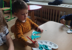 Chłopiec wykonuje choinkę.