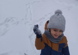 Chłopiec bierze udział w bitwie na śnieżki.
