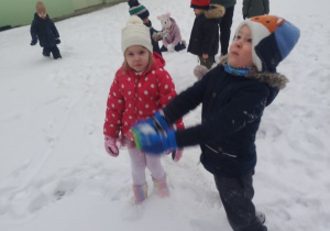 Dzieci bawią się na śniegu.