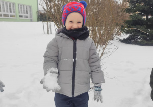 Chłopiec uśmiecha się do zdjęcia.