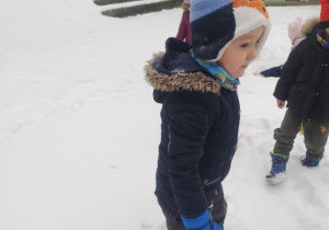 Chłopiec obserwuje zabawy innych dzieci.