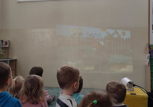 Dzieci oglądają bajkę na projektorze.