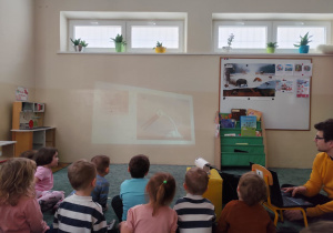 Dzieci oglądają bajkę na projektorze.