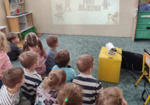 Dzieci oglądają bajkę na projektorze.