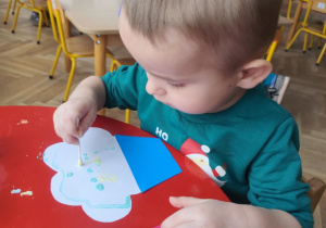 Chłopiec wykonuje zaproszenie dla babci.