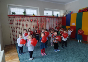 Dzieci tańczą z balonami w kształcie serc.