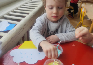 Chłopiec wykonuje zaproszenie dla babci.