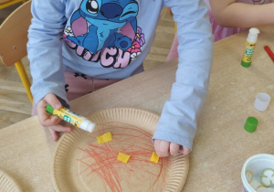 Dziewczynka wykonuje własną pizzę.