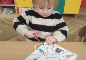 Dziewczynka wycina sylwety instrumentów.