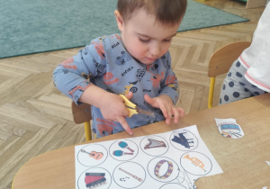 Chłopiec wycina sylwety instrumentów.