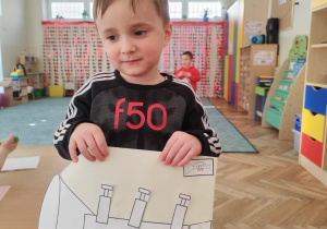 Chłopiec prezentuje własną trąbkę.