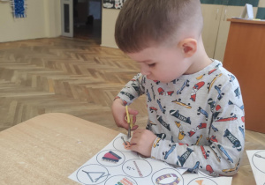 Chłopiec wycina sylwety z instrumentami.