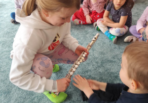Dzieci oglądają flet poprzeczny.