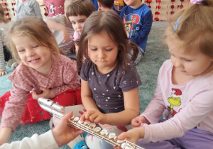 Dzieci oglądają flet poprzeczny.